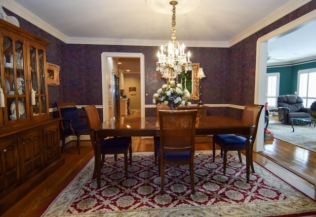 dining room featuring hardwood / wood-style flooring, crown molding, and a notable chandelier