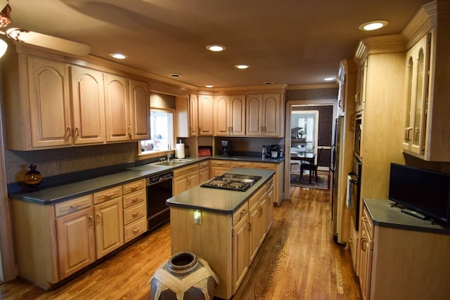 kitchen with sink, wood-type flooring, black appliances, a kitchen island, and light brown cabinetry