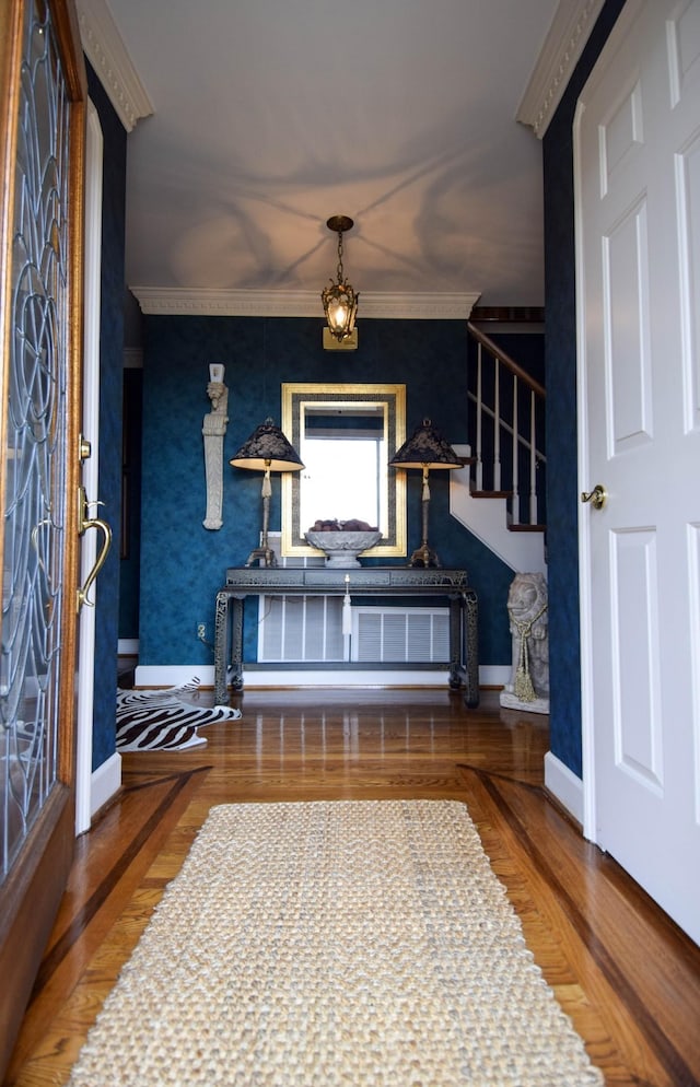 entryway with hardwood / wood-style flooring and crown molding