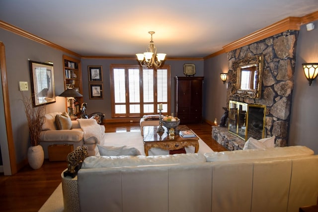 living room featuring ornamental molding, dark hardwood / wood-style floors, a stone fireplace, and a notable chandelier