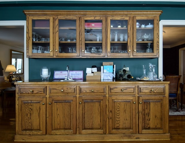 bar with dark wood-type flooring and ornamental molding