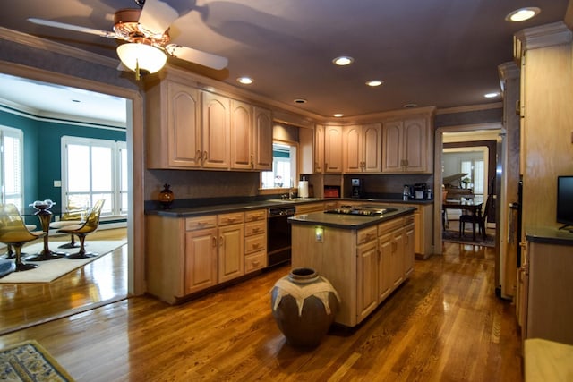 kitchen featuring dark wood-type flooring, ornamental molding, black appliances, and a center island