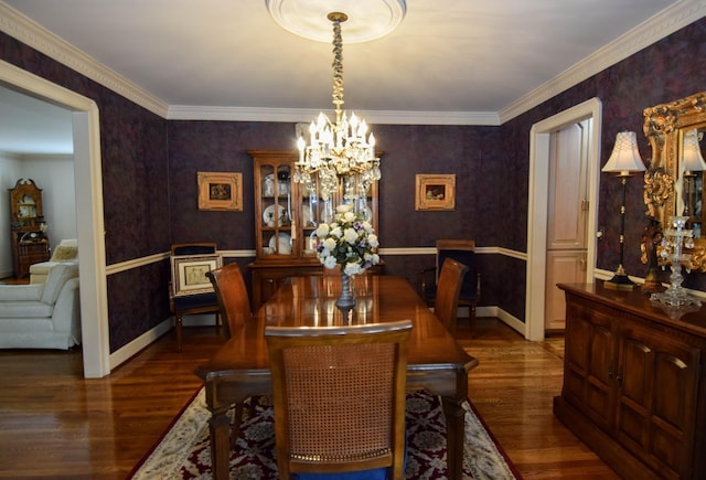 dining room with crown molding, dark hardwood / wood-style floors, and an inviting chandelier