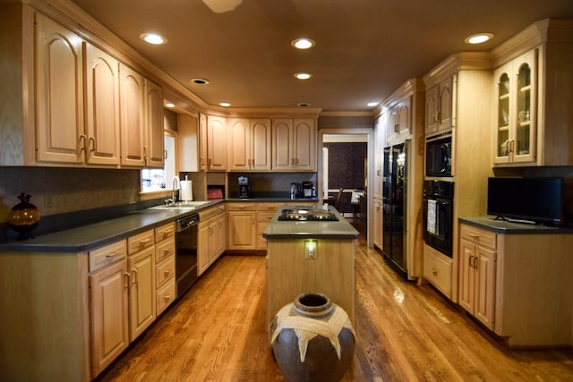 kitchen featuring hardwood / wood-style floors, sink, a center island, black appliances, and light brown cabinets