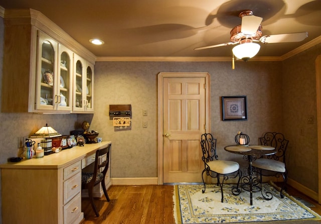 interior space with ceiling fan, ornamental molding, and hardwood / wood-style floors