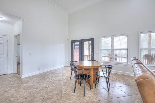 tiled dining area featuring crown molding, high vaulted ceiling, and french doors