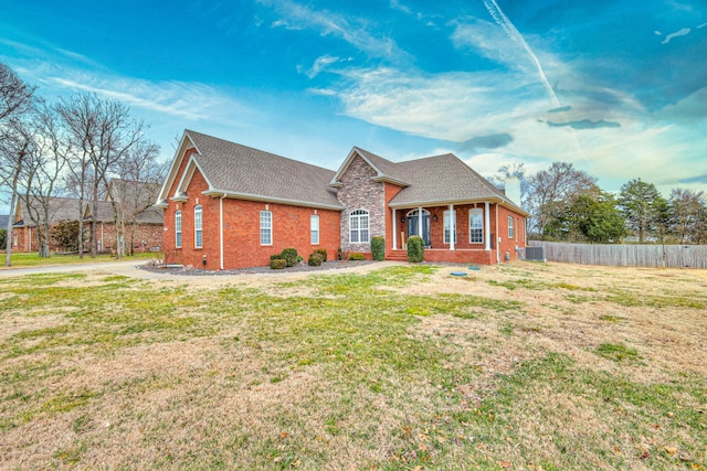 view of front of home with central AC unit, covered porch, and a front lawn