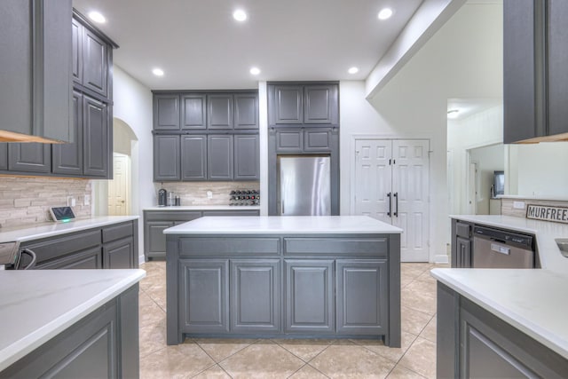 kitchen with gray cabinetry, tasteful backsplash, stainless steel appliances, and light tile patterned flooring