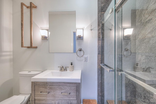 bathroom featuring vanity, an enclosed shower, and toilet