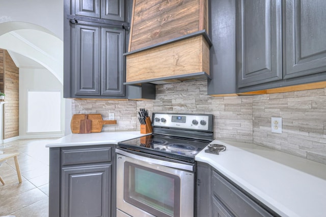 kitchen featuring light tile patterned floors, gray cabinets, backsplash, electric range, and ornamental molding