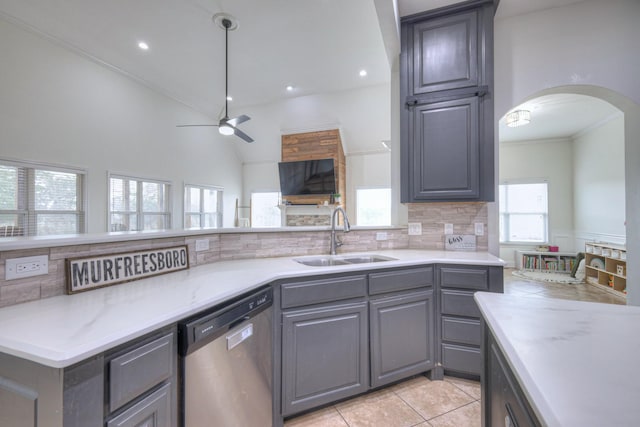 kitchen with light tile patterned flooring, sink, stainless steel dishwasher, gray cabinets, and backsplash