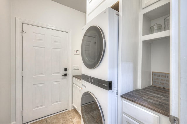 clothes washing area featuring stacked washer / dryer and light tile patterned floors