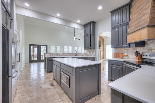 kitchen with sink, gray cabinetry, a center island, kitchen peninsula, and stainless steel appliances