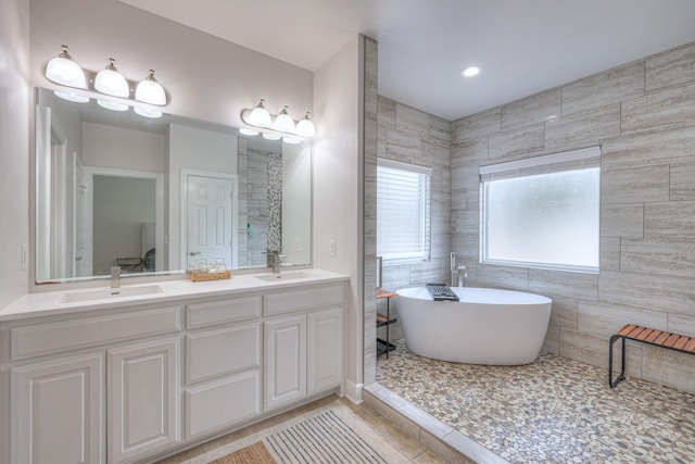 bathroom featuring tile patterned flooring, vanity, and a washtub