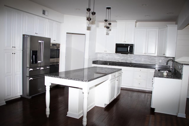 kitchen featuring sink, white cabinetry, a center island, appliances with stainless steel finishes, and pendant lighting