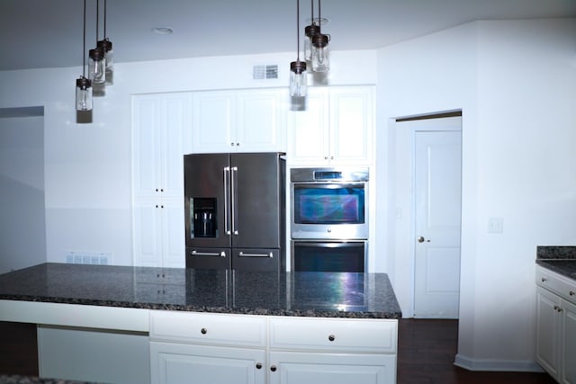 kitchen featuring stainless steel appliances, white cabinets, dark hardwood / wood-style flooring, decorative light fixtures, and dark stone counters