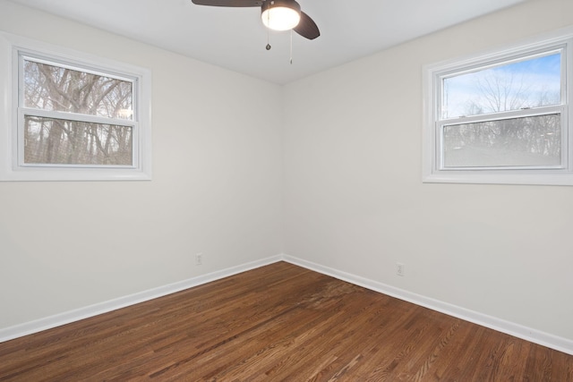 spare room featuring a ceiling fan, baseboards, and wood finished floors