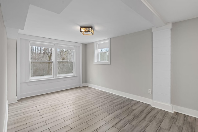 empty room with light wood-style flooring and baseboards