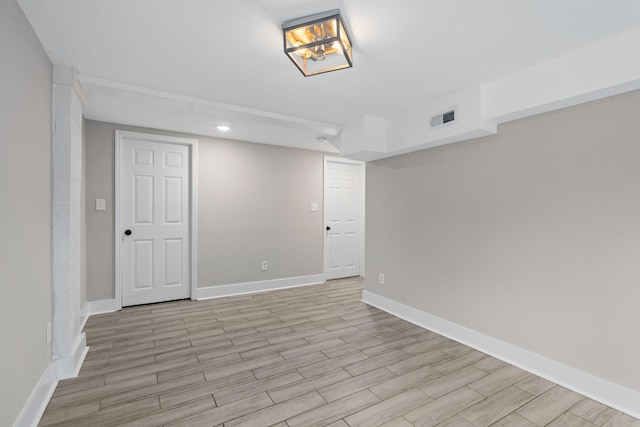 unfurnished room with light wood-type flooring, baseboards, and visible vents