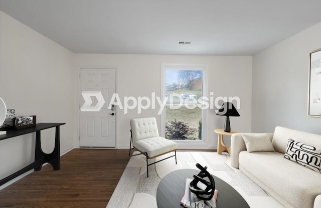 living area with dark wood-style floors, visible vents, and baseboards