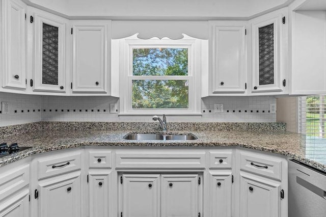 kitchen with white cabinetry, sink, stainless steel dishwasher, and light stone countertops