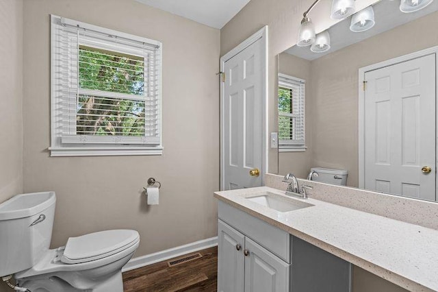 bathroom featuring vanity, wood-type flooring, and toilet