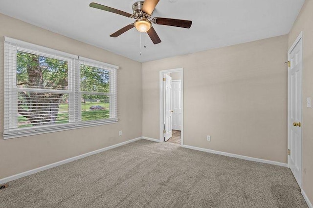 carpeted spare room with ceiling fan