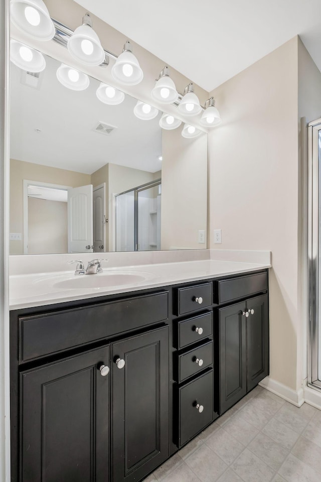 bathroom featuring vanity, a shower with shower door, and tile patterned floors