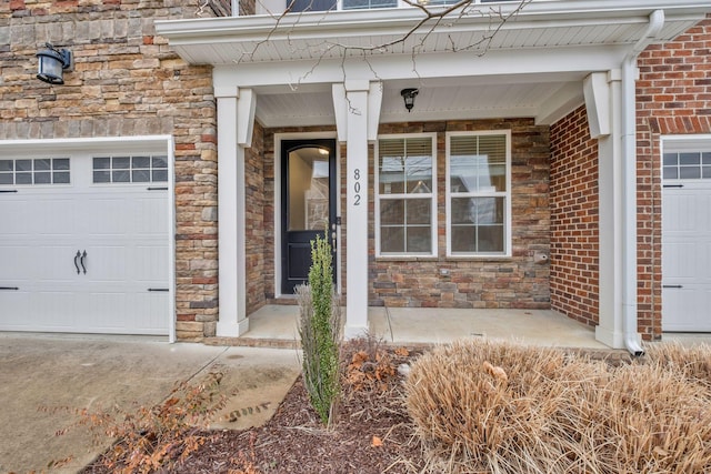 view of exterior entry featuring a porch and a garage