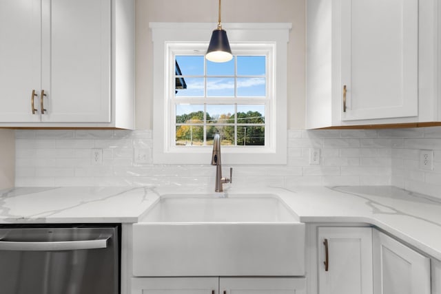 kitchen featuring pendant lighting, sink, white cabinetry, light stone counters, and stainless steel dishwasher