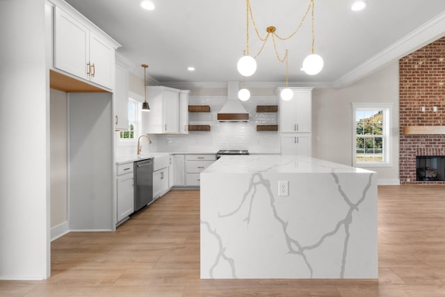 kitchen featuring pendant lighting, stainless steel appliances, light stone counters, white cabinets, and a kitchen island