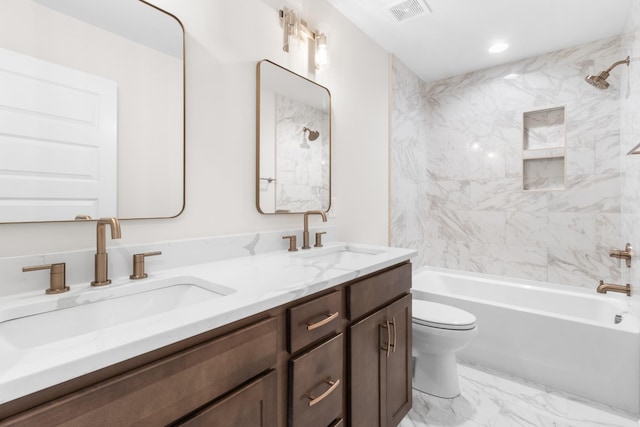 full bathroom featuring tiled shower / bath, vanity, and toilet