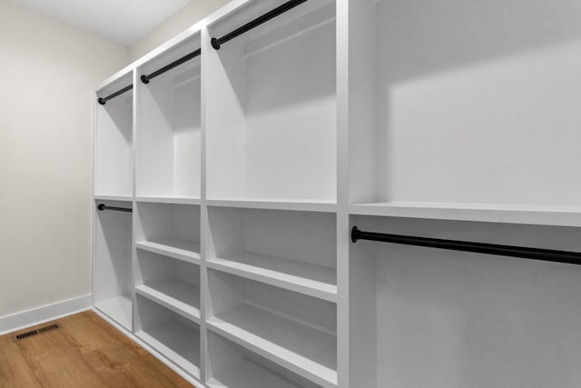 walk in closet with light hardwood / wood-style flooring