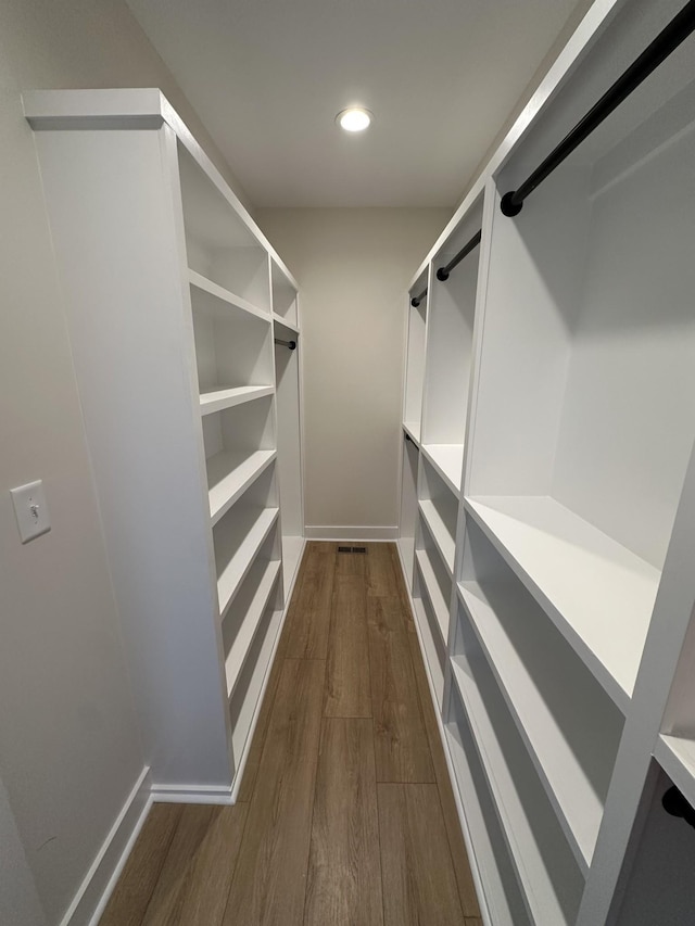 spacious closet featuring dark hardwood / wood-style flooring