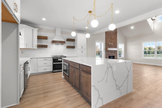 kitchen featuring white cabinetry, premium range hood, a kitchen island, and appliances with stainless steel finishes