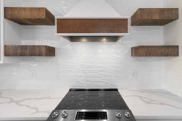 kitchen featuring light stone counters, decorative backsplash, and electric stove