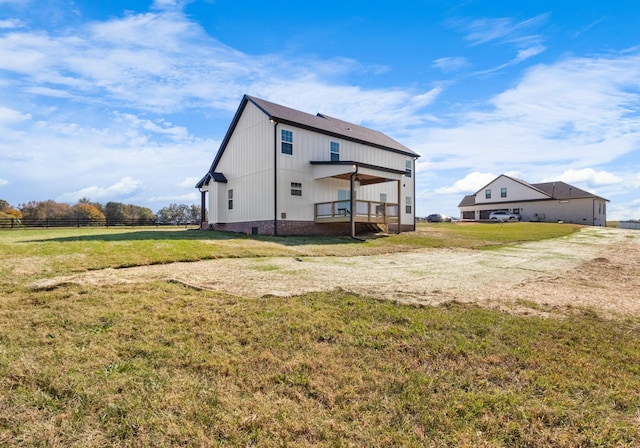 rear view of property with a rural view and a yard