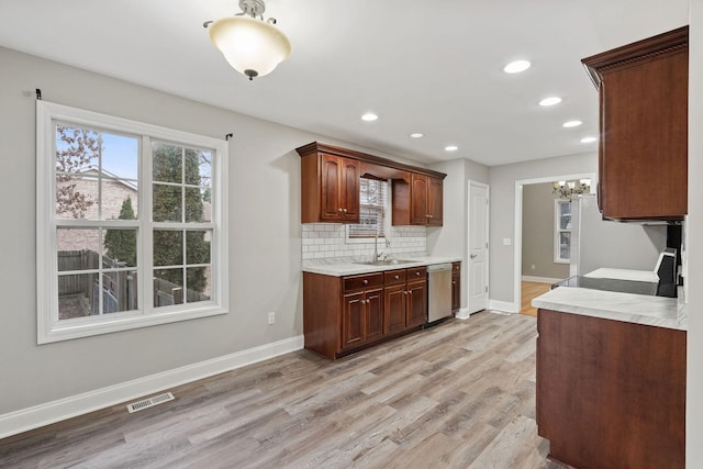 kitchen with dishwasher, sink, decorative backsplash, fridge, and light wood-type flooring