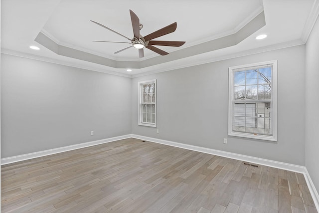 unfurnished room with ceiling fan, a raised ceiling, and light wood-type flooring