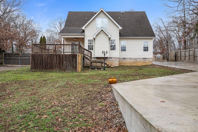 back of property with a wooden deck and a lawn