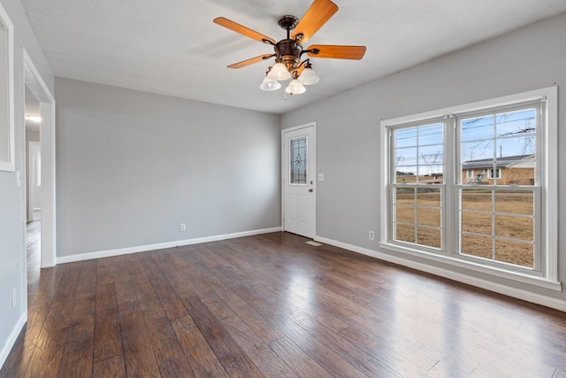 empty room featuring dark wood-type flooring and ceiling fan