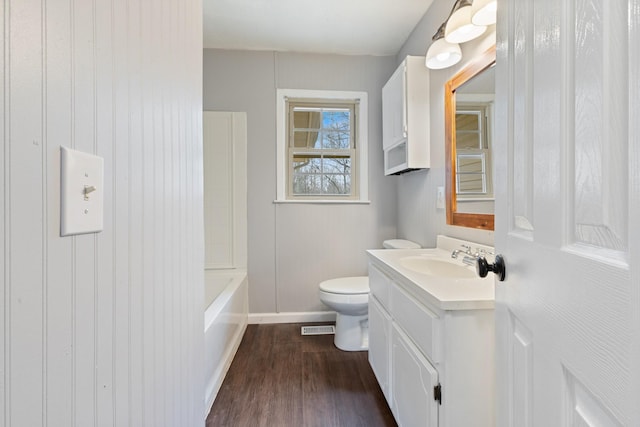 full bathroom with vanity, tub / shower combination, hardwood / wood-style floors, and toilet