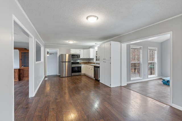 kitchen featuring white cabinetry, sink, dark hardwood / wood-style flooring, stainless steel appliances, and crown molding