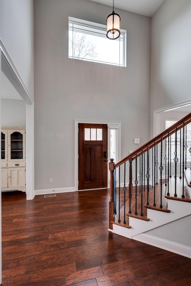 foyer entrance featuring dark hardwood / wood-style flooring and a high ceiling