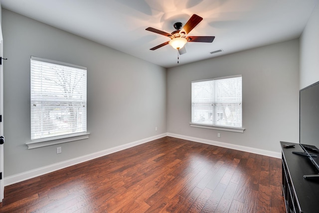 empty room with dark wood-type flooring and ceiling fan