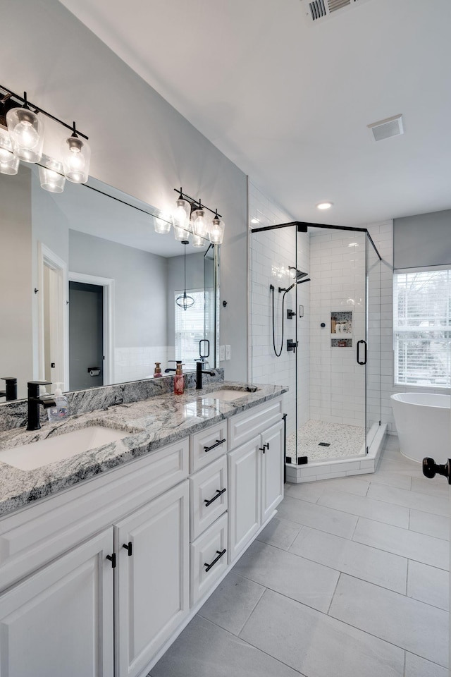 bathroom with shower with separate bathtub, plenty of natural light, vanity, and tile patterned floors