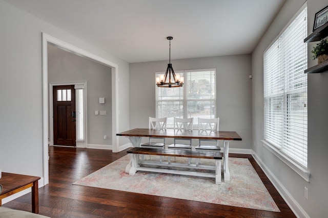 dining area with dark hardwood / wood-style floors and a chandelier