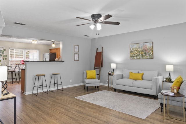 living room with ceiling fan and light wood-type flooring