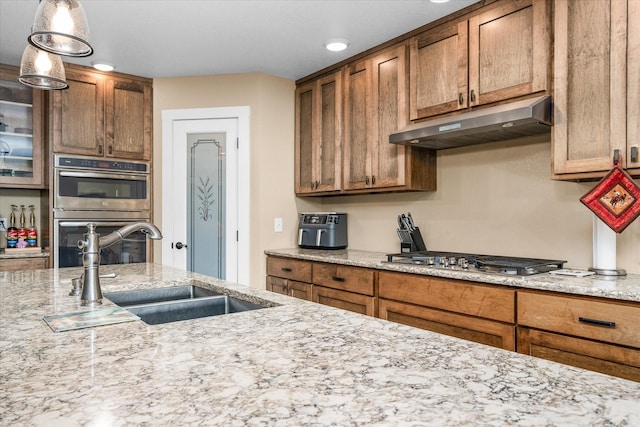 kitchen featuring light stone counters, sink, and appliances with stainless steel finishes