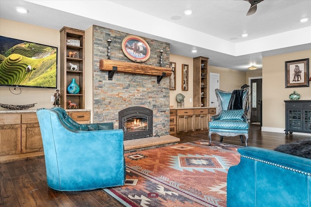 living room featuring ceiling fan, dark wood-type flooring, and a fireplace